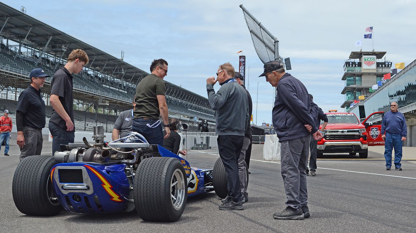 Museum staff debriefing with Sebastian Saavedra after testing a vintage indycar.