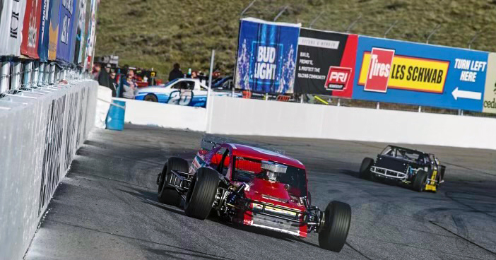 Cars on track with PRI Membership banner in the back