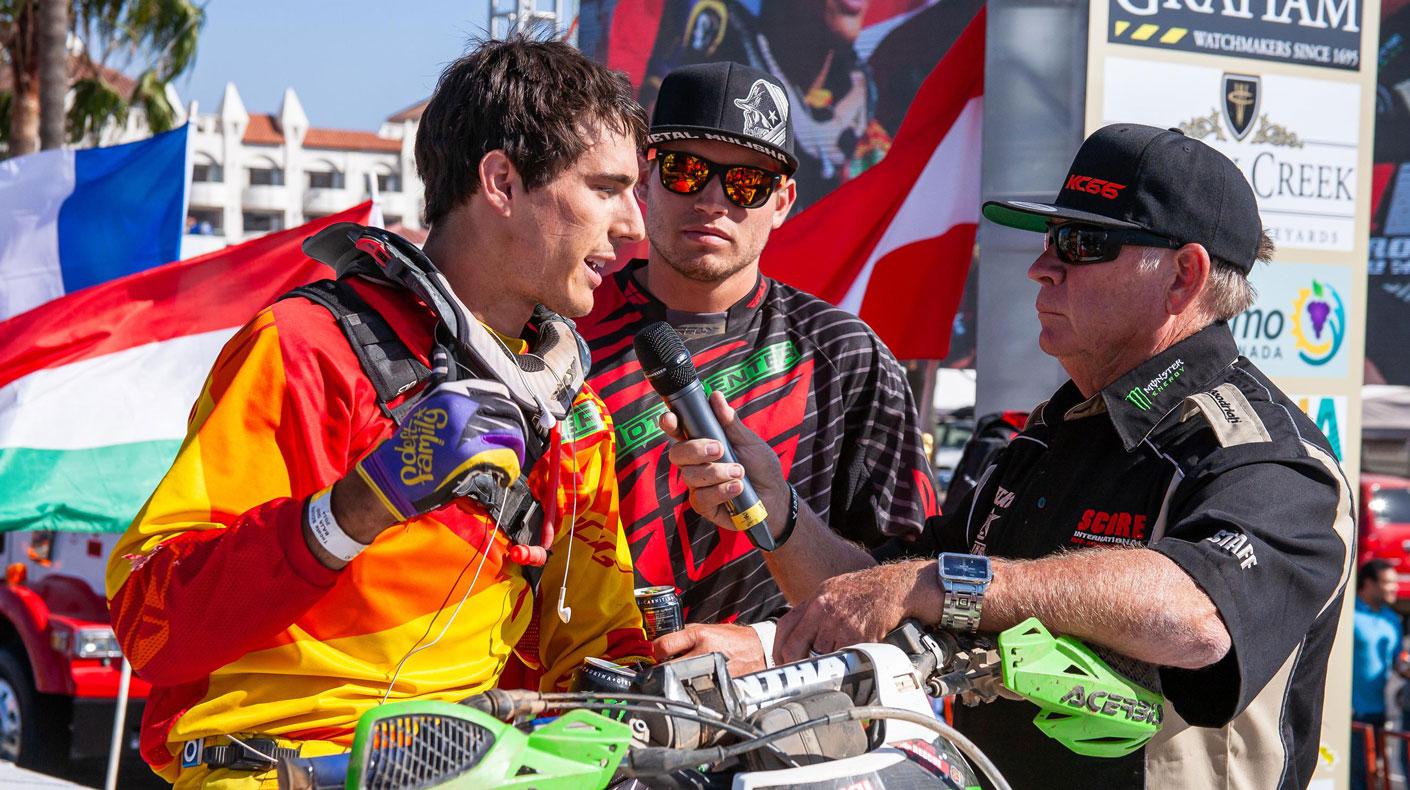 George Antill, far right, interviews a SCORE racer