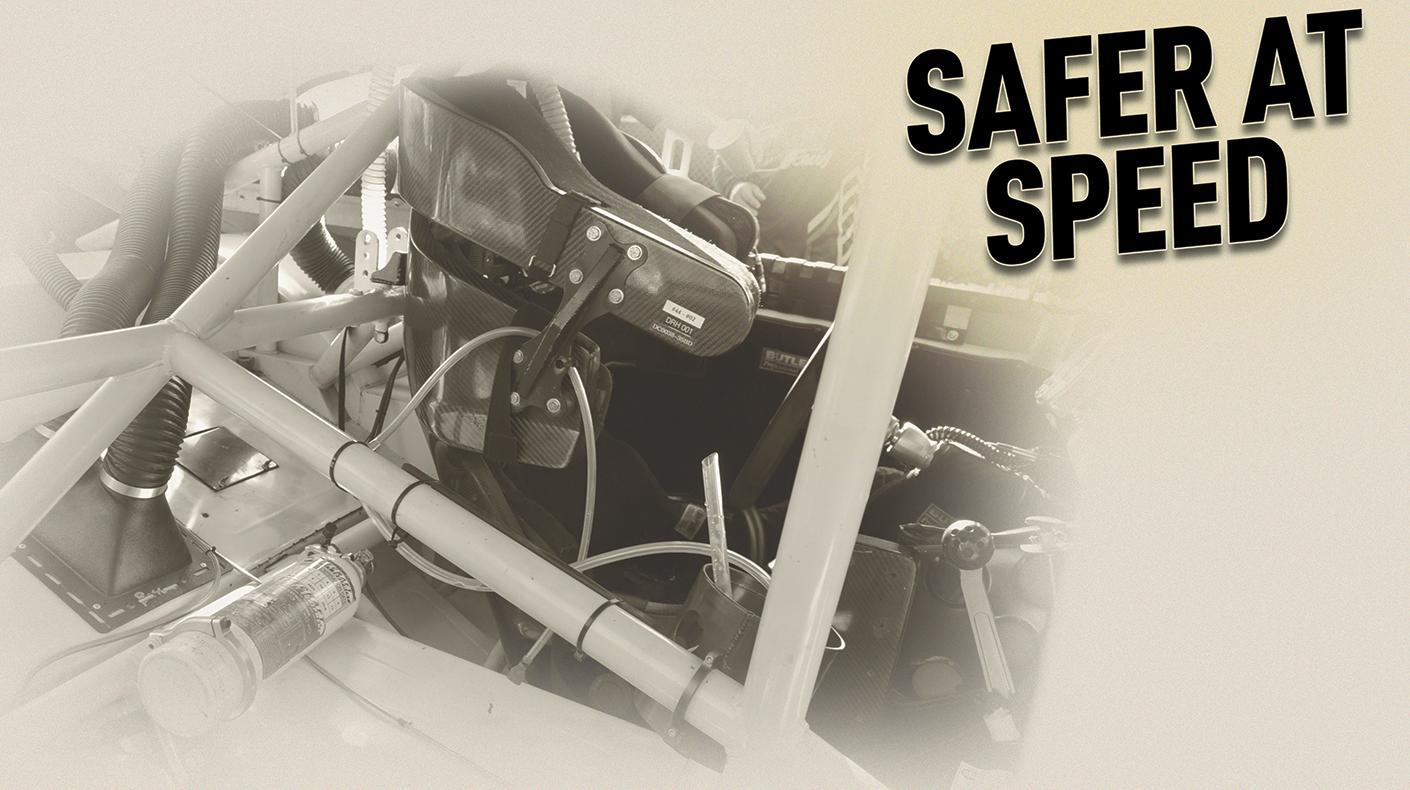 Inside of a stock car cockpit with the words "Safer at Speed" over the top.