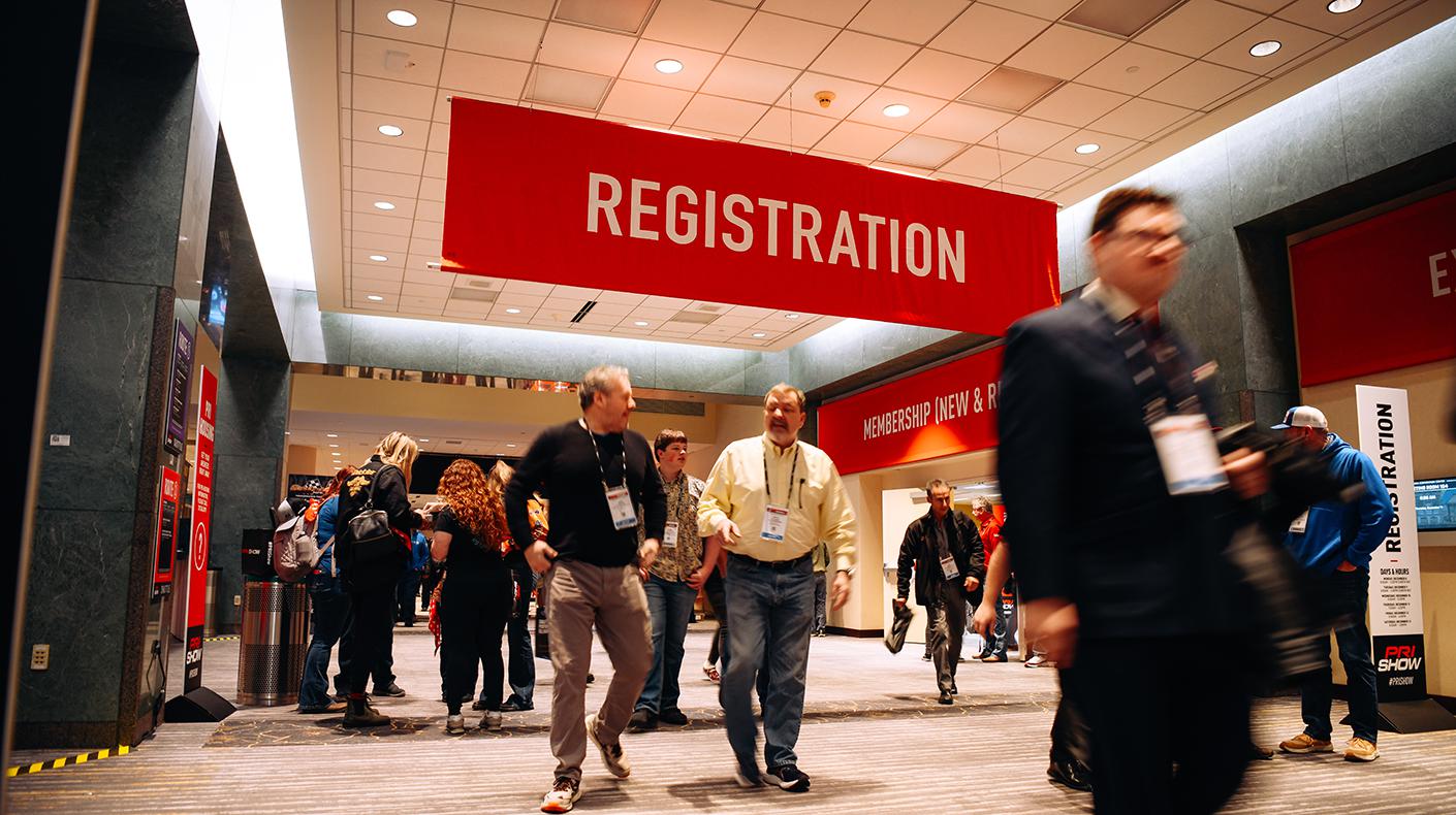 People walking through PRI Show registration.