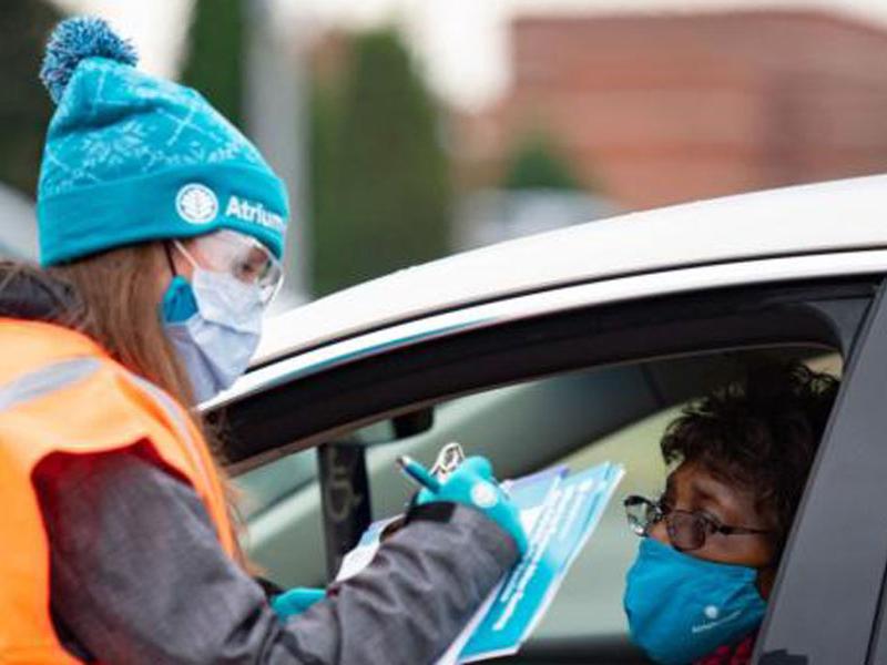 Photo courtesy of Atrium Health. Healthcare worker and person in car at drive through vaccination site