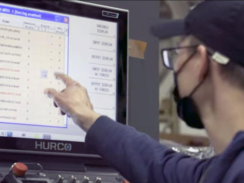 Two industry professionals working on a Hurco machine