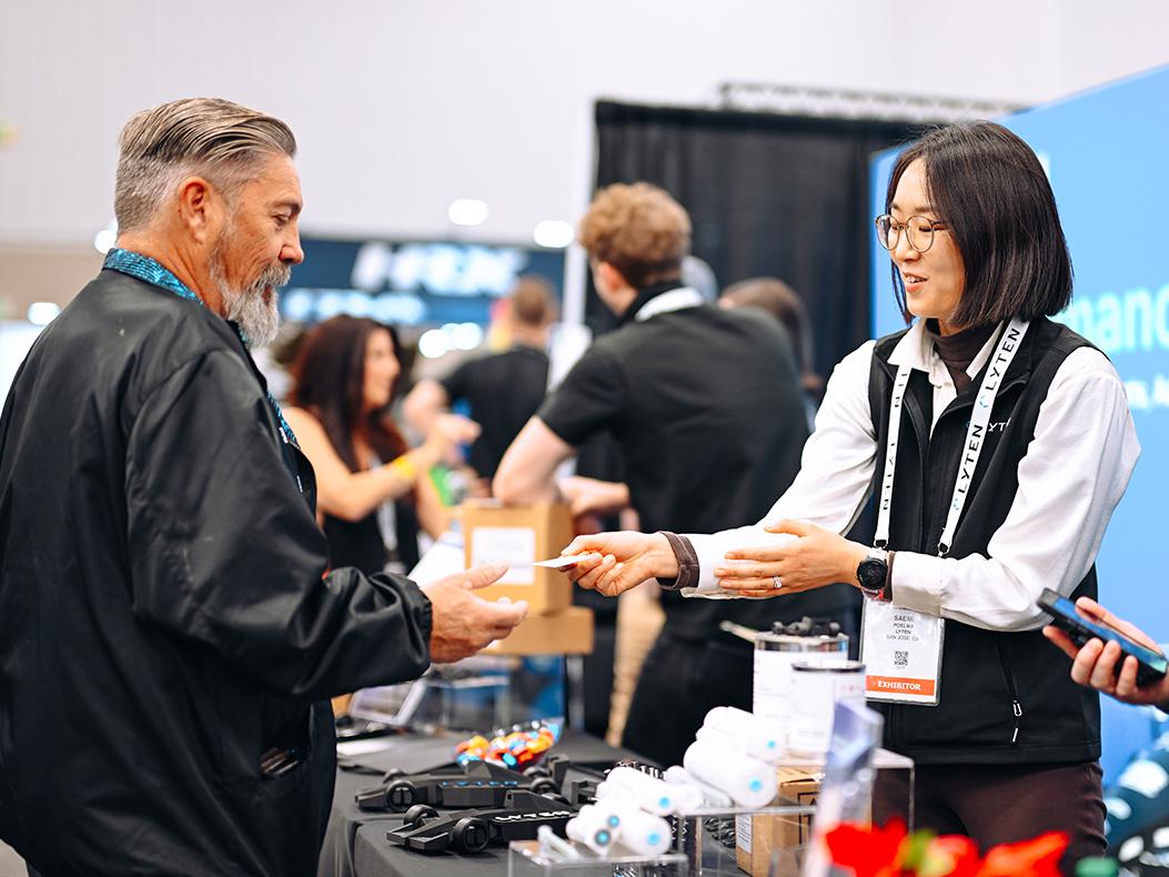 PRI Show exhibitors talking about their products with a PRI Show attendee. 