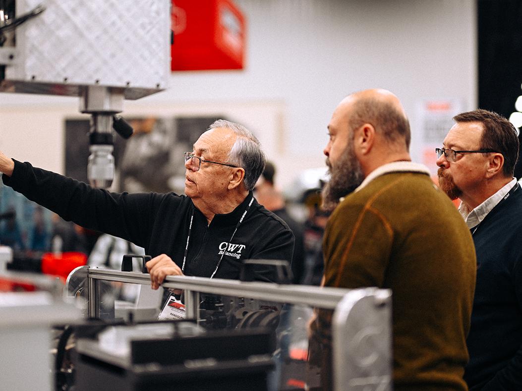 An exhibitor speaking with attendees at the PRI Show.