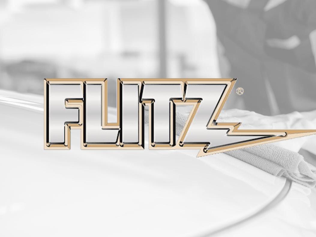The Flitz logo over a person wiping down the hood of a car.