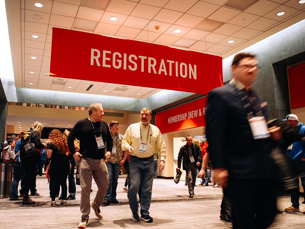 People walking through PRI Show registration.